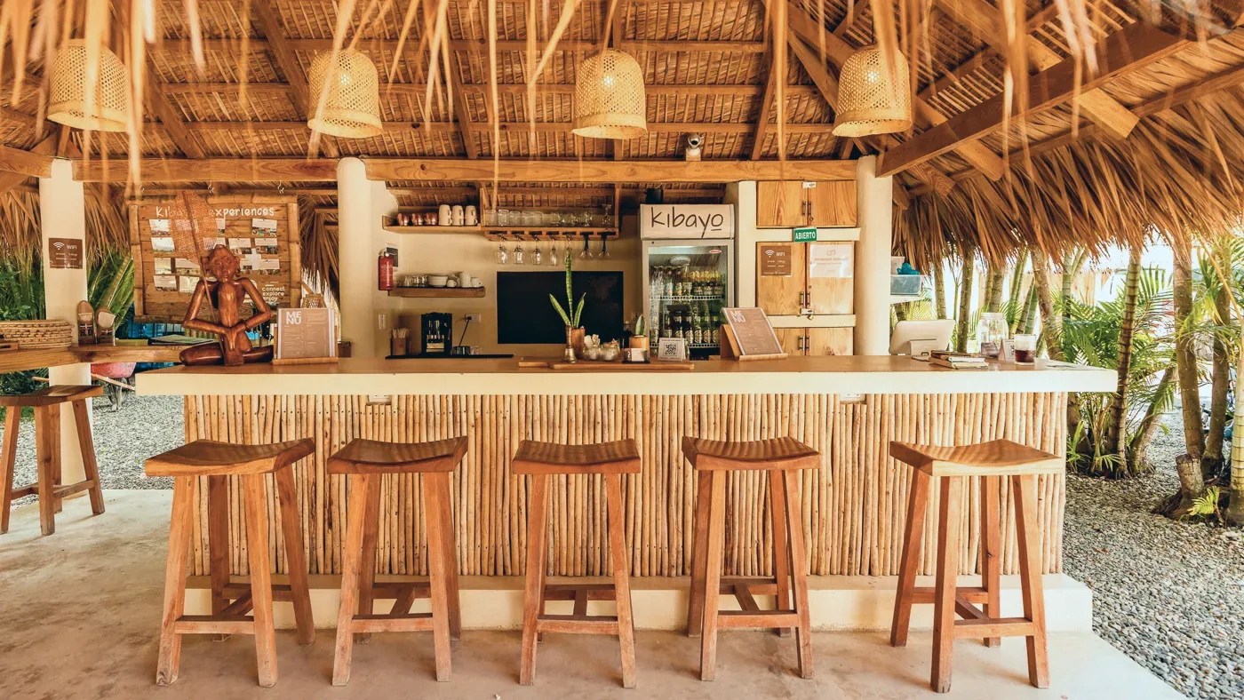 The bar with wooden stools under the thatched roof